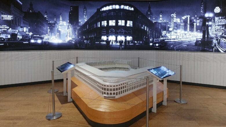 Maqueta de Ebbets Field expuesta en el Jackie Robinson Museum de Nueva York, con una imagen nocturna del estadio de los Brooklyn Dodgers al fondo.