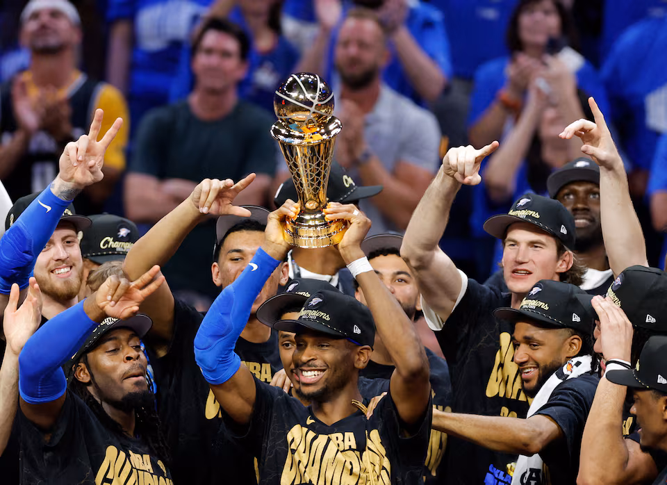 Gros plan sur Shai Gilgeous-Alexander tenant le trophée de MVP des Finales NBA 2025 avec un large sourire