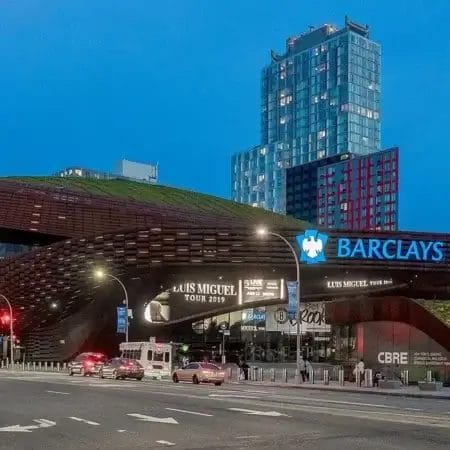 Façade futuriste du Barclays Center illuminée à la tombée de la nuit à Brooklyn