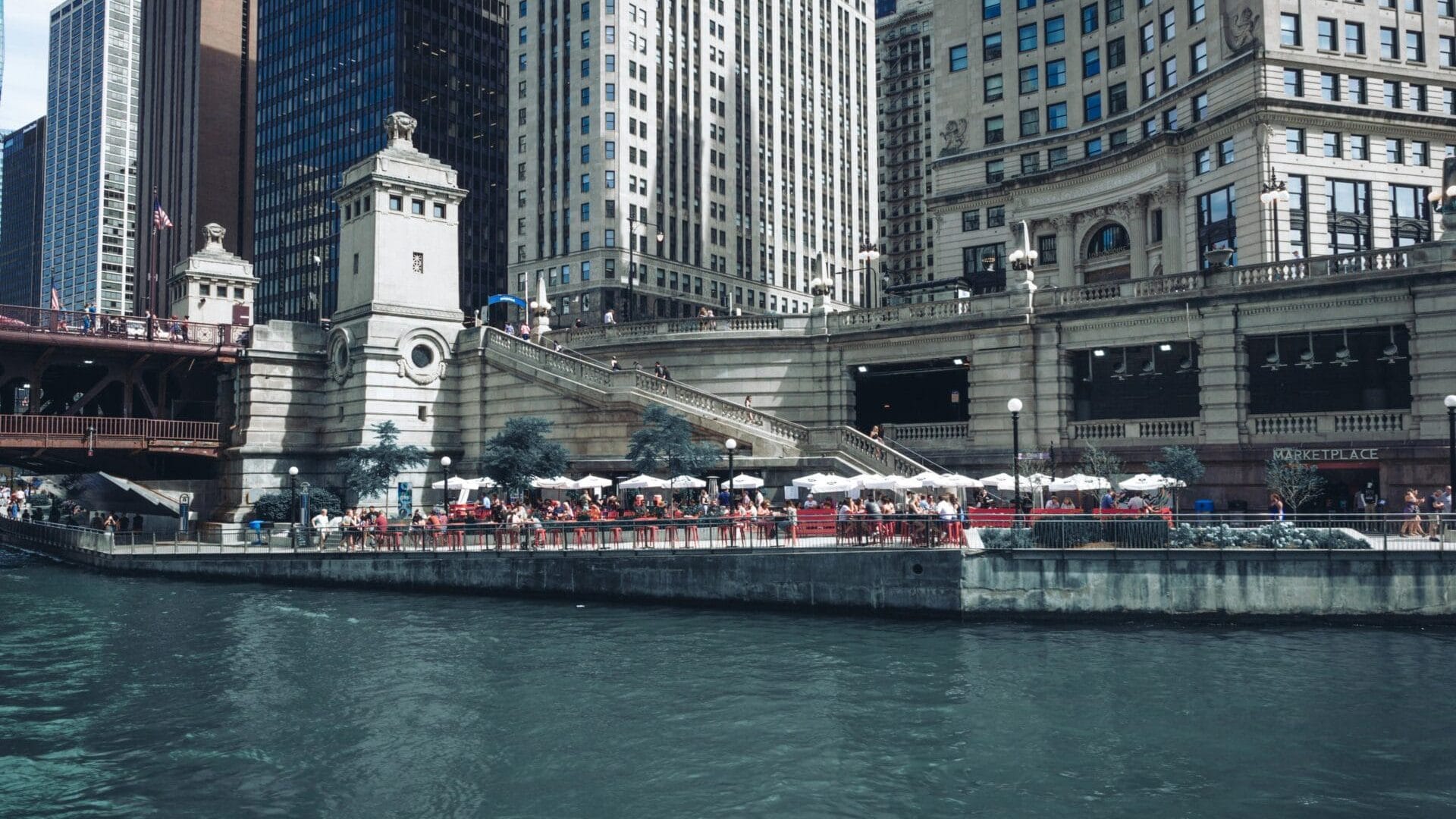 Chicago Riverwalk – Terrasses & DuSable Bridge (Michigan Avenue) Chicago Riverwalk : terrasses au bord de l’eau et escaliers face au DuSable Bridge sur Michigan Avenue