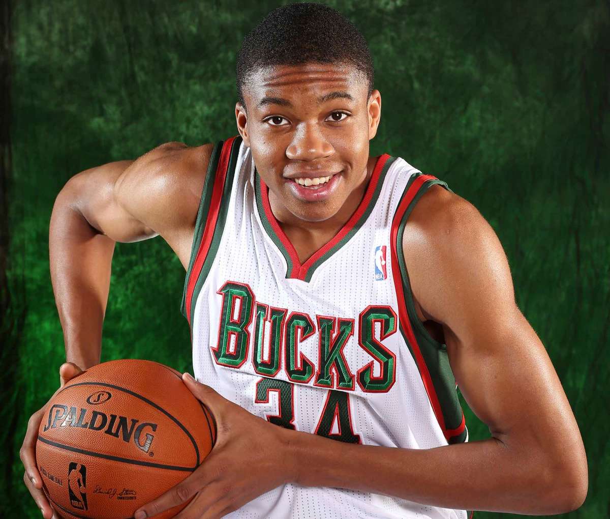 Jeune Giannis Antetokounmpo en maillot Bucks, saison rookie 2013, tenant un ballon Spalding