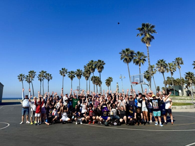 Grupo de viajeros Trip Double en la cancha de baloncesto de Venice Beach, bajo las palmeras