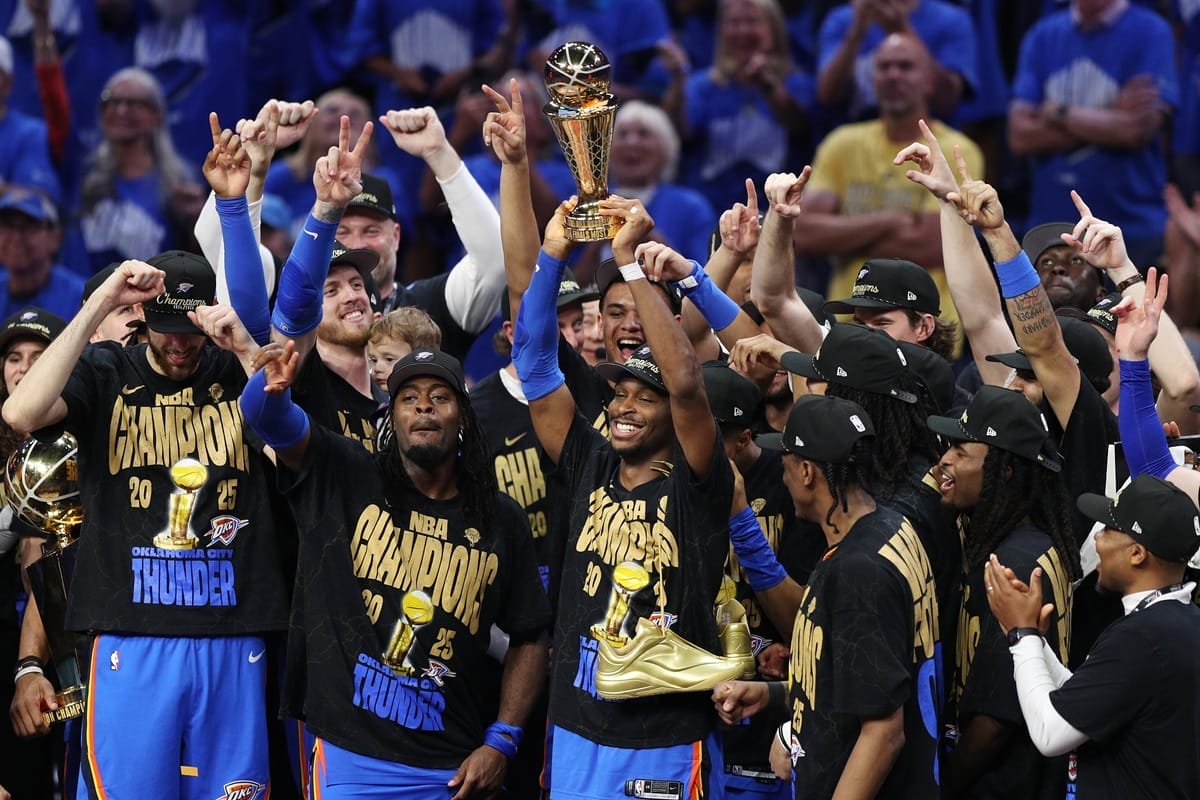 Los jugadores del Oklahoma City Thunder celebran su título NBA 2025 levantando el trofeo en la cancha