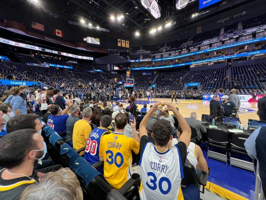 Fans en bord de terrain au Chase Center, échauffement de Stephen Curry lors d’un voyage Trip Double