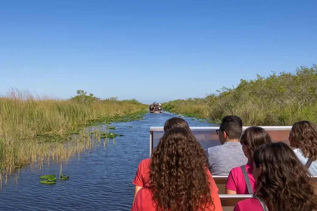 Excursion en airboat dans les Everglades avec passagers à l'avant et marais autour