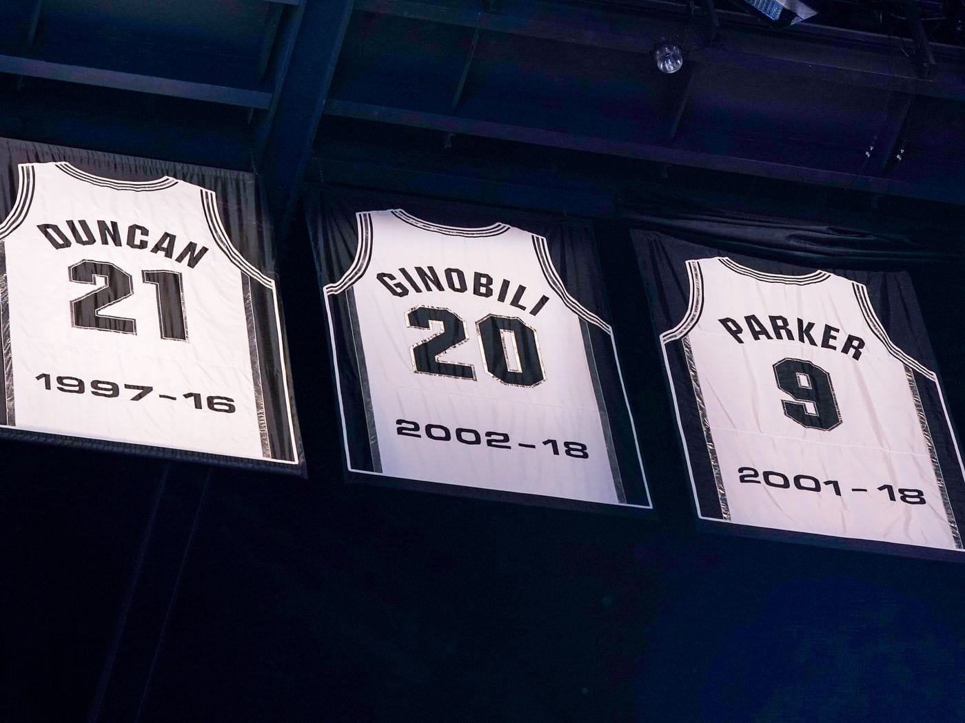 Les maillots retirés de Tony Parker, Manu Ginóbili et Tim Duncan accrochés au plafond de la salle des Spurs