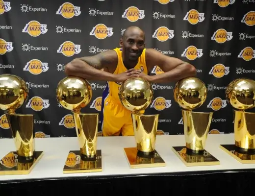 Kobe Bryant pose fièrement avec ses 5 trophées NBA sous le maillot des Lakers
