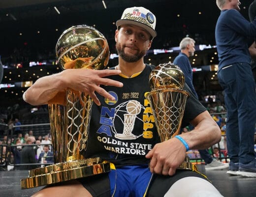 Stephen Curry posant avec le trophée NBA et le MVP des Finales 2022