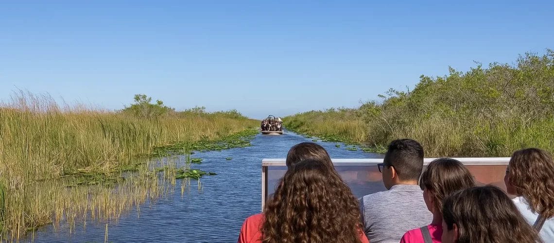 Excursion en airboat dans les Everglades avec passagers à l'avant et marais autour